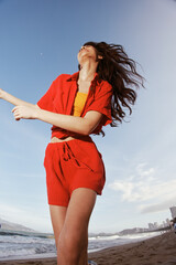 Canvas Print - Dancing in the Summer Breeze, a Smiling Woman Enjoys Freedom and Fun by the Sunny Sea