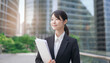 © tenpadasi - 朝のオフィスビル・オフィス街の笑顔の日本人女性会社員ポートレート　ビジネス・仕事・新入社員・若者　　