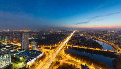 Wall Mural - Aerial cityscape at twilight with illuminated streets