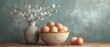 a painting of eggs in a bowl next to a vase with a branch of a blossoming tree in it.