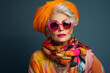 Extravagant senior woman portrait. Stylish grandmother dressing elegant clothes with modern eclectic accessories. Funny old woman, cool senior fashion model on colored background