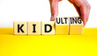 © Dzmitry - Kid or kidulting symbol. Concept words Kid or Kidulting on wooden cubes. Beautiful yellow table white background. Psychologist hand. Healthy lifestyle and kid or kidulting concept. Copy space.