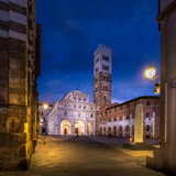 Fototapeta Paryż - Lucca, Italy - July 29, 2023: Romanesque façade and bell tower of Saint Martin’s Cathedral in Lucca, Tuscany. It contains the most precious relic of Lucca