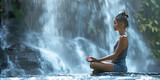 Fototapeta Tęcza - Young asian woman sitting in lotus position beside a huge waterfall in evening with low light -  calmly taking time to meditate listening to the crashing water with copy space for a spiritual message 