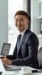© gustav - A handsome young Chinese man in a suit is smiling and holding coffee while sitting at his desk, with a laptop on the table. created by ai