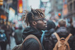 An individual standing on the street looking at the crowd is portrayed in a style that includes bold colorism, texture-rich layers, distinct facial features, and abrasive elements.