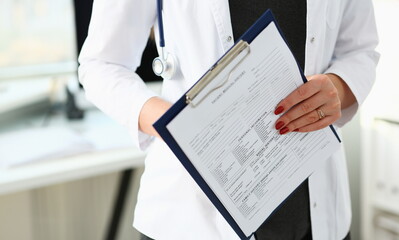 Wall Mural - Female doctor hand holding and filling patient history list at clipboard pad during physical. Exam er disease prevention ward round visit check 911 prescribe remedy healthy lifestyle concept.