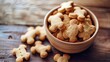 A bowl of homemade cookies is a dog treat on a wooden background. Natural organic homemade cookies for pets. The concept of healthy organic dog food.