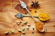 © peopleimages.com - Spoons, spice and selection of seasoning for health on kitchen table, turmeric and cardamom for meal. Top view, condiments and options for spicy gourmet in Indian culture, art and food preparation
