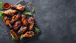 Barbecued chicken wings with herb garnish on a plain background with copy space. International chicken wing day, grilling month concept 