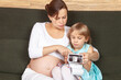 Expectant Mother and Daughter Looking at Ultrasound