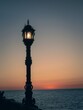 Sunset and a lonely lamppost at the avenida Campo del Sur in Cadiz Spain
