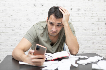 Wall Mural - Close up of unhappy man sitting at the table, stressed and confused by calculate expense from invoice or bills, have no money to pay mortgage or loan. High prices and spending money concept