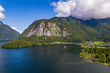 Aerial view of the lake, village, fields and forest in mountains Alps Austria