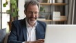 © Lars - A happy businessman, executive manager, smiles while engaged in a laptop video conference online call meeting at home