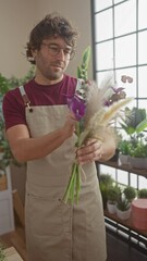 Poster - Smiling man with beard arranging a bouquet in a flower shop filled with greenery