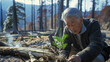 Banner with an elderly man planting a tree seedling in the ground, after a fire in the forest, banner for Earth Day. Each tender seedling represents a promise for the future