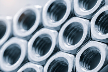 Poster - A close up of many nuts and bolts. The nuts and bolts are all the same size and are arranged in a row