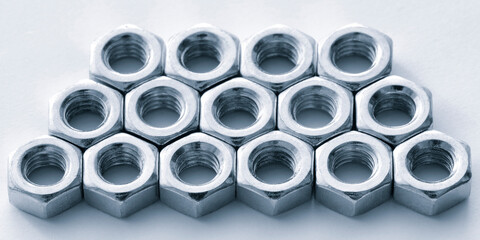 Poster - A close up of many nuts and bolts. The nuts and bolts are all the same size and are arranged in a row