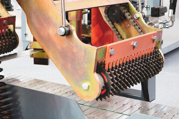 Poster - a machine with a chain and a red and orange handle. the chain is made of metal and has a lot of spik