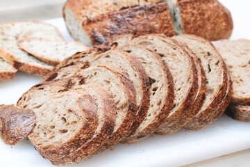 Poster - A close up of a loaf of bread with a few slices missing. The bread is brown and has a crusty texture