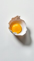 Cracked open egg shell containing a yellow yolk inside on a white background