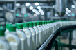 Conveyor belt with uniform milk bottles and green caps at dairy production plant