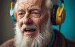 Happy elderly man with beard wearing headphones sings joyfully