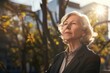 senior old business woman photographic portrait, sunlight, background, looking up with hope, dream