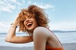 © SHOTPRIME STUDIO - Happy Afro-Curly Lady Laughing Outside: A Cheerful Portrait of a Young Attractive Woman with Beautiful Curly Hair Enjoying a Sunny Day at the Beach, Surrounded by Cool Ocean and a Friendly Natural