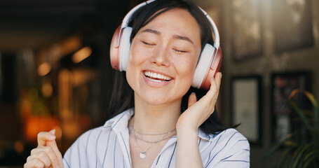 Poster - Happy asian woman, headphones and listening to playlist music in cafe for audio streaming, dancing or singing. Female person or freelancer smile or enjoying podcast, sound or song at coffee shop or r