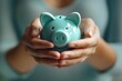 Closeup image of a woman holding piggy bank in hands for saving money and financial concept