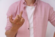 A man in a pink shirt is making a hand gesture with his thumb up. Concept of frustration or annoyance