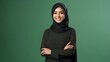 Close-up portrait of attractive arabic woman wearing scarf and crossing hand on green background. Business concept