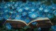 Open book with blue flowers in the garden. Springtime concept