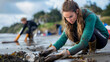 A young woman cleans up a polluted beach to capture conservation efforts and dedication to the environment.
