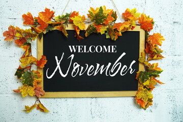 Poster - Welcome November text message on chalkboard with maple leaf decoration