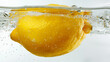 A whole lemon submerged in water on white background