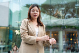 Fototapeta Desenie - Asian white collar business woman standing outside office city building
