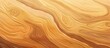 A closeup of a hardwood surface with a swirling pattern in amber and brown tones. The wood stain and varnish enhance the natural beauty of the plywood flooring