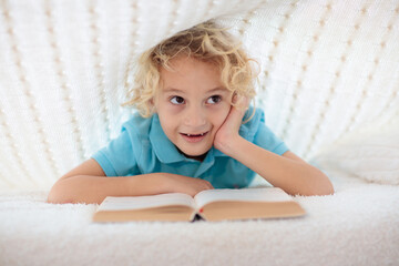 Poster - Child reading book in bed. Kids read books.