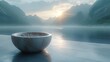 a large bowl sitting on top of a stone floor next to a body of water with mountains in the background.