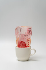 Wall Mural - Taiwanese dollar banknote in a cup