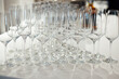 Many empty champagne glasses stand on the table