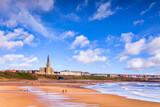 Fototapeta  - Tynemouth, Tyne and Wear, UK - People take a walk on the beach at Tynemouth on a bright spring day.