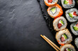 Frame of a bright sushi set of rolls on a black background with space for text. Concept banner template for advertising restaurants, Asian cuisine and menus.