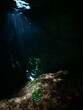 a green plastic bottle in a cave underwater ocean pollution with sun beams and rays