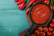 Italian tomato sauce. Homemade spicy tomato sauce or ketchup with cherry tomato and chili pepper for pasta and pizza in pan old wooden rustic background. Top view.
