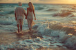 Couple of old mature people walking on the sand together and having fun on the sand of the beach enjoying and living the moment. Two cute seniors in love having fun. Barefoot walking on the water. 