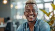 Joyful African man with a modern bleached hairstyle and a denim jacket, giving off a trendy and happy vibe in a creative setting